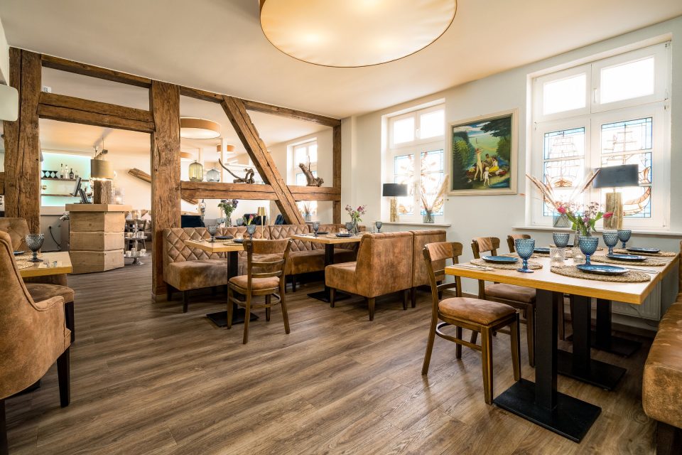Restaurant Blaue Maus Innenraum — gedeckte Tische, Stühle, Wandgemälde und Buntglasfenster